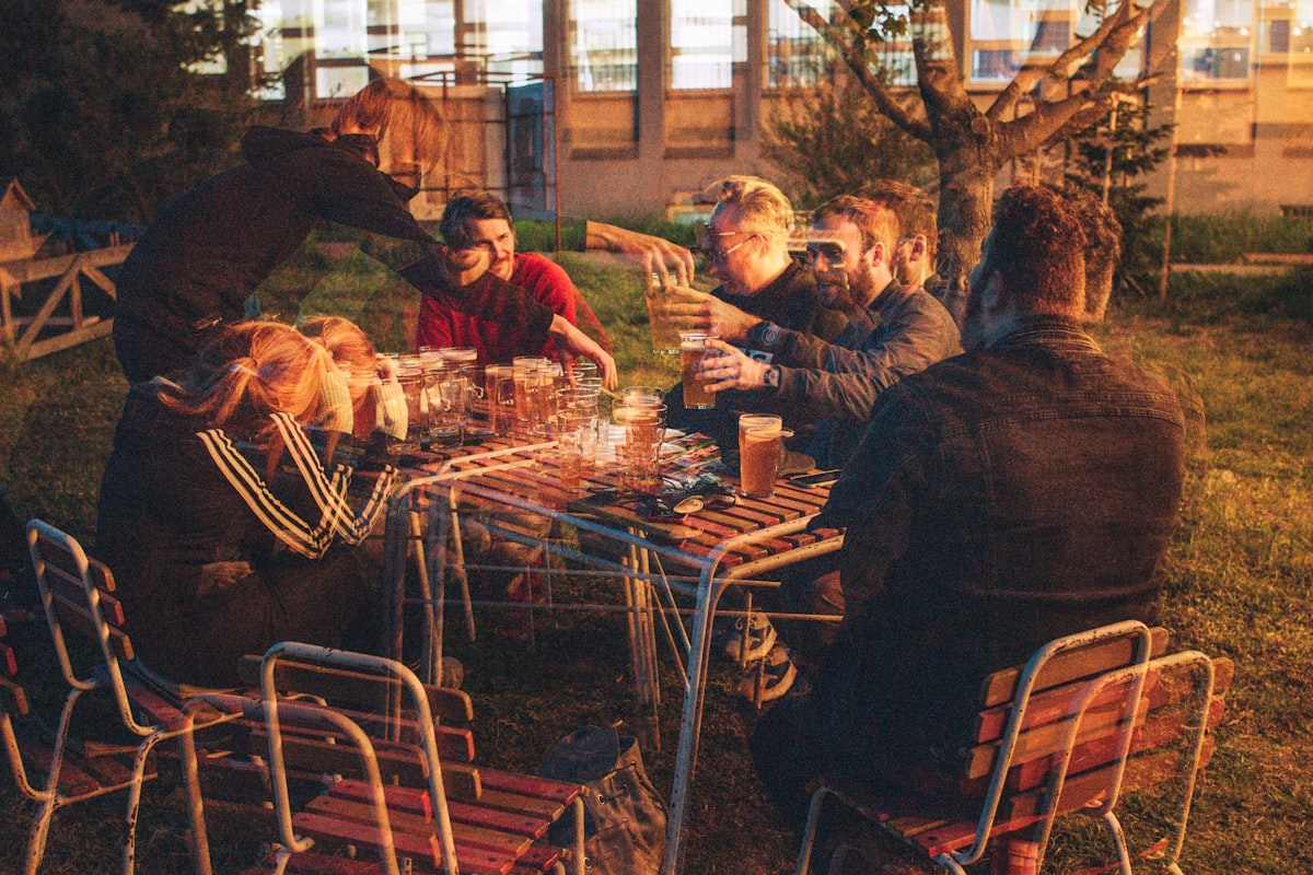 Friends gathered around an outdoor table at golden hour.